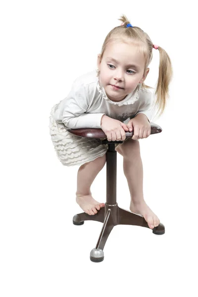 Kleines Mädchen liegt auf einem Schemel — Stockfoto