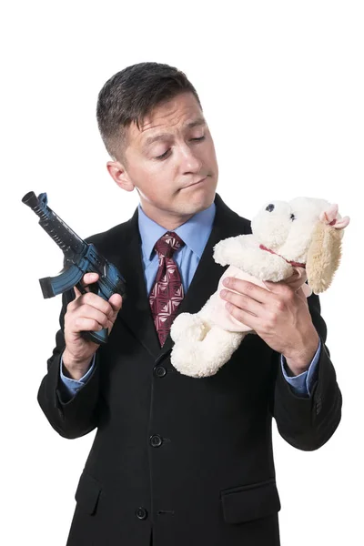 Бізнесмен з пістолетом і плюшевою іграшкою — стокове фото
