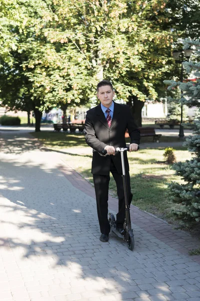 Biznesmen na skuter w parku — Zdjęcie stockowe