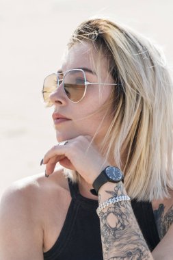 Güneş gözlüğü ona dövme olan güzel bir kadın portresi yüz, yakın çekim