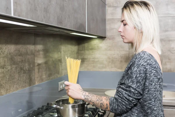 La mujer está cocinando espaguetis —  Fotos de Stock