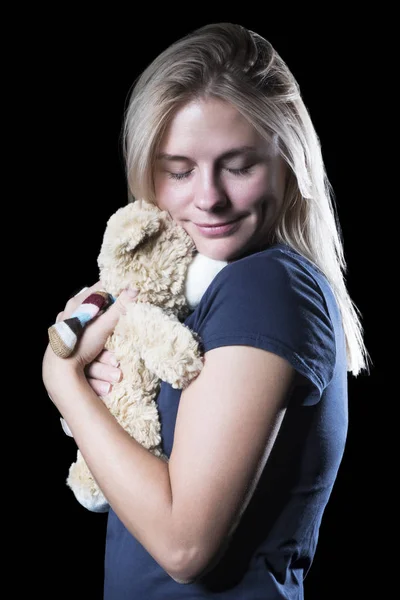 Vrouw knuffelen een teddybeer — Stockfoto