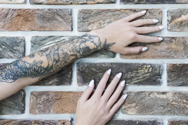 Женские руки на кирпичной стене — стоковое фото