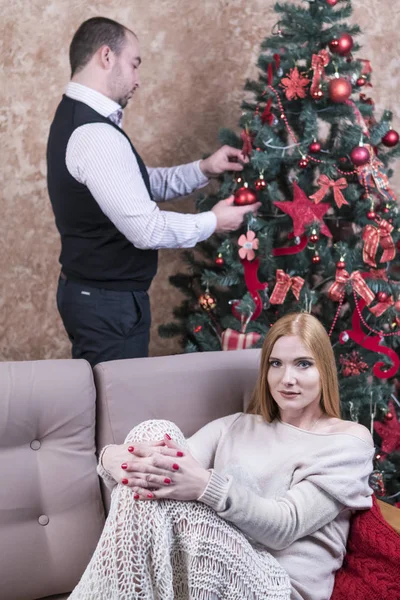 Ehemann schmückt den Weihnachtsbaum — Stockfoto