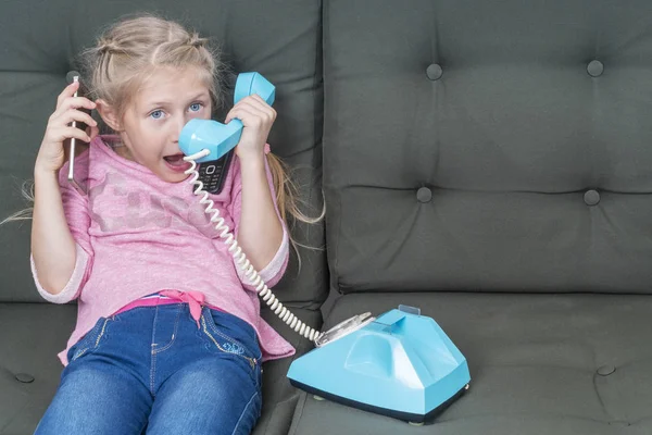 Niña Sentada Sofá Está Hablando Tres Teléfonos Diferentes Diferentes Generaciones — Foto de Stock
