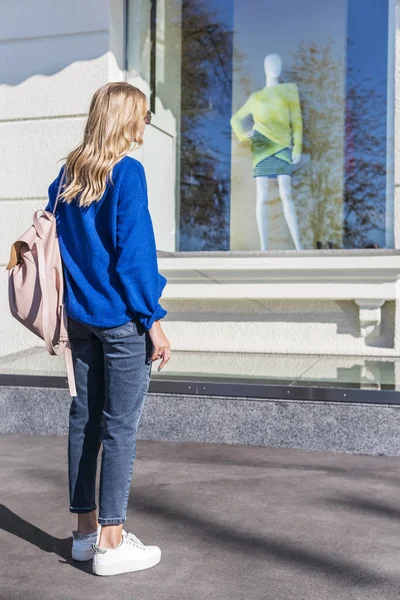 Kvinna Står Framför Ett Skyltfönster Med Skyltdocka Moderiktiga Kläder — Stockfoto