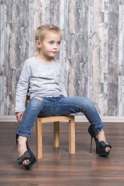 Klein kind in haar moeder schoenen — Stockfoto