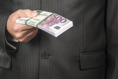işadamı para bir bohça ile 500 euro, closeup nominal değerinin tutan takım elbiseli