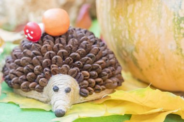 Çocuklar el sanatları - kirpi kahvenin üzerinde sarı sonbahar üzerinden iğneleri ile yaprakları