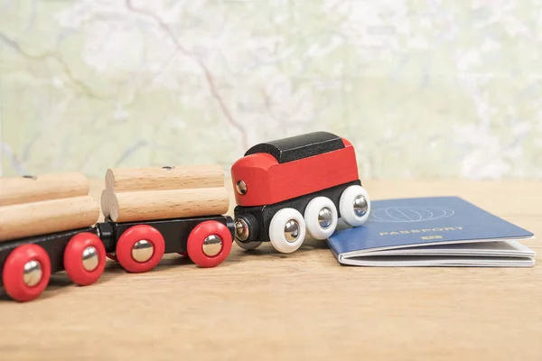 红色玩具火车在一张旧木桌上的生物识别护照上跑过 — 图库照片