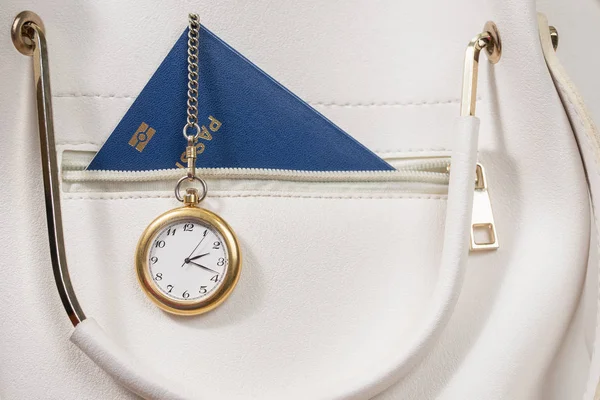 watch on the passport in a pocket female white bag - the concept of time to go on vacation