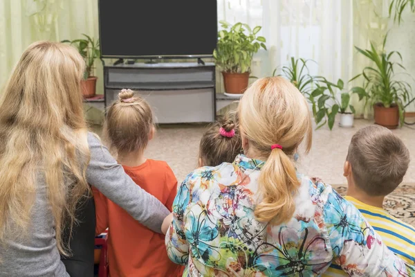 Família no chão na TV — Fotografia de Stock