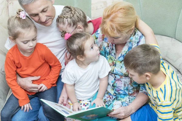 Großeltern bringen Enkeln Lesen bei — Stockfoto