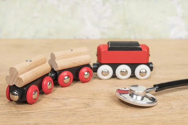 旧木桌上的听诊器和玩具火车 — 图库照片