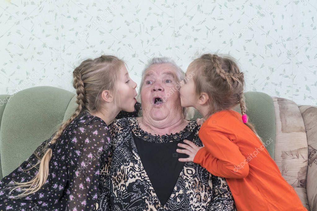 Two granddaughters kiss their great-grandmother cheeks, which opened her mouth in surprise