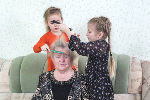 Zwei Mädchen Kämmen Urgroßmutter Die Auf Einem Sofa Zimmer Sitzt — Stockfoto