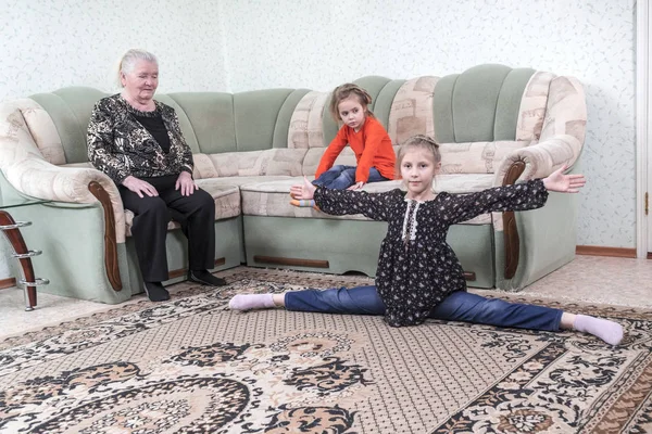 Lány Megmutatja Torna Hasít Hogy Nővére Nagy Nagymamája Kanapén — Stock Fotó