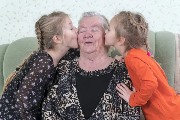 Zwei Mädchen Küssen Ihre Urgroßmutter Von Beiden Seiten Auf Die — Stockfoto