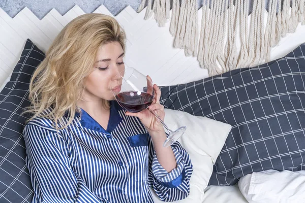 Женщина пьет вино в постели — стоковое фото