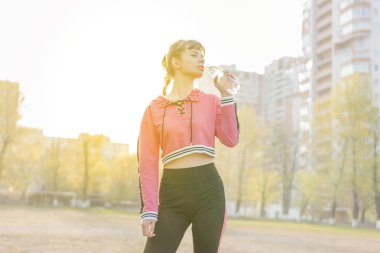 Sportif kadın şişeden su içiyor.