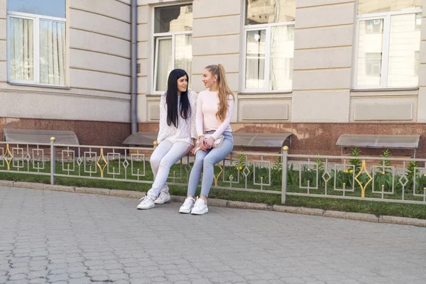 Duas mulheres conversam sentadas na cerca — Fotografia de Stock