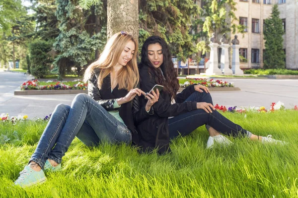 Два студента сидят на траве — стоковое фото