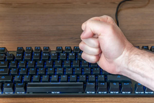 man fist hitting the keyboard