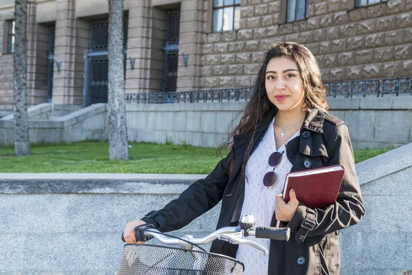 Студент с книгой на велосипеде — стоковое фото