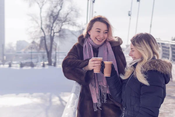 Две смеющиеся женщины с чашками кофе — стоковое фото