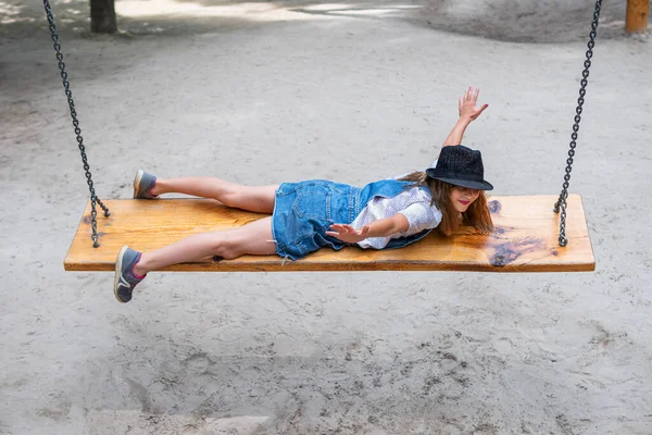 Dívka ležící jezdí na houpačce — Stock fotografie