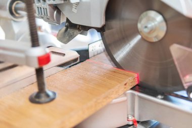 Dairesel testere lazer işaretli seviyedeki tahtayı keser. Tahta çilingir kıskacına sıkışmış..
