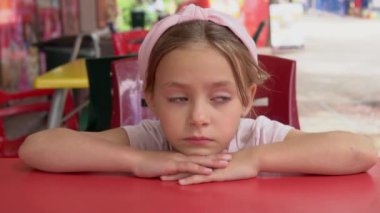 Masadaki düşünceli çocuğun portresi.