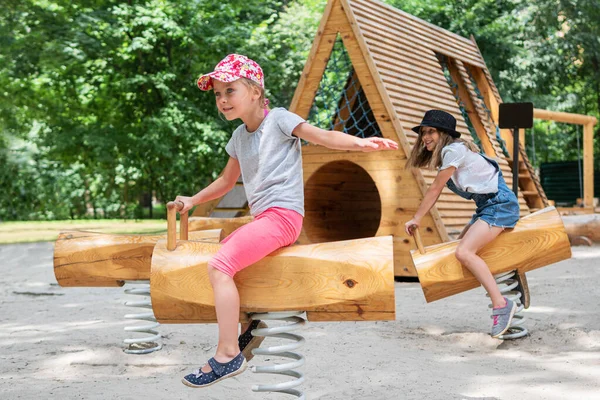 Children riders on wooden swing — Stock Photo, Image