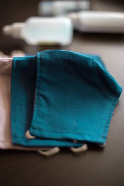 Karanlık Arkaplan 'da üç şişe dezenfektanla yüz maskeleri takan kişi, gaz, buhar, gaz ve toz gibi partikül maddeler gibi tehlikeli atmosferleri solumaktan korunuyor.