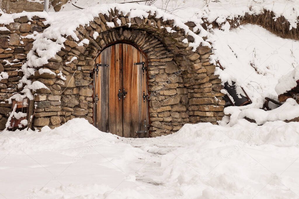 Small door made of stones during winter time. High quality photo