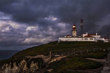 Dramatik gece Portekizce üzerinde sahil, Atlantik Okyanusu, anakara Europe Cabo da Roca adlı en batıdaki nokta manzara. Eski deniz feneri.