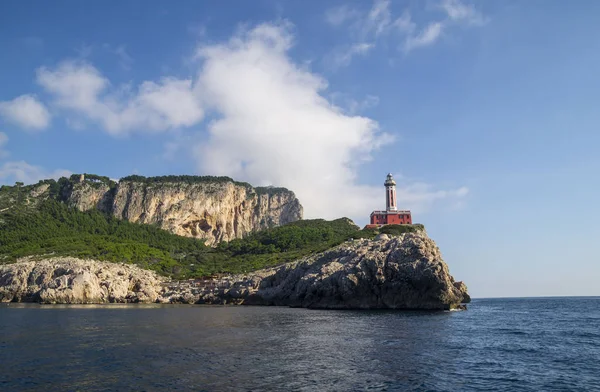 Punta Carena Deniz Feneri Capri adasında Akdeniz'de kıyı kayalar üzerinde, bir motorlu tekne turu görüldü.