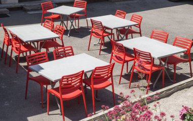 Kafe masaları ve sandalyeler sokakta.