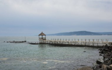 Bulgaristan'ın sahil beldesi ve Balçık'ta Karadeniz kıyısında bir iskele ile doğal karamsar manzara 