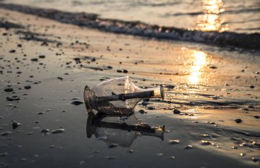 Gün doğumunda sahilde şişede mesaj. Duvar sanatı ve ev dekorasyonu.