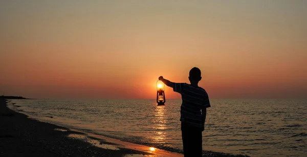 Kleiner Junge Mit Lampe Bei Sonnenaufgang Strand — Stockfoto