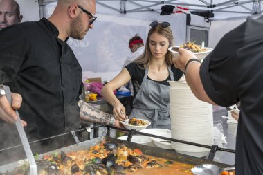 Köstence, Romanya - 20 Mayıs 2017. Festival midyesi 2017'de insanlar. Şefler Romanya'nın Eski Şehir Köstence sokaklarında ünlü Catalin Scarlatescu Chef , bir tarifi sonra midye pişirmek.