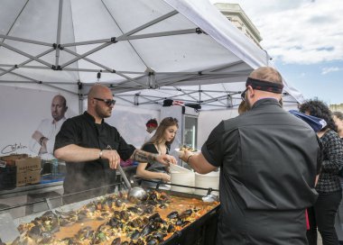 Köstence, Romanya - 20 Mayıs 2017. Festival midyesi 2017'de insanlar. Şefler Romanya'nın Eski Şehir Köstence sokaklarında ünlü Catalin Scarlatescu Chef , bir tarifi sonra midye pişirmek.