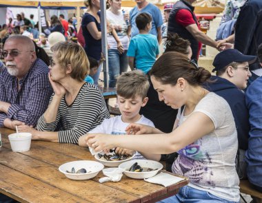 Köstence, Romanya - 20 Mayıs 2017. Festival midyesi 2017'de insanlar. Şefler Romanya'nın Eski Şehir Köstence sokaklarında ünlü Catalin Scarlatescu Chef , bir tarifi sonra midye pişirmek.