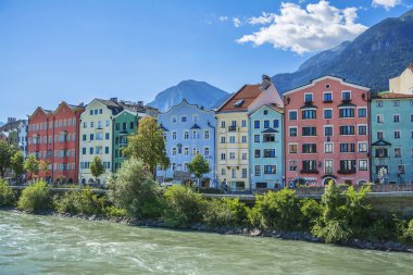 Innsbruck, Tirol, Avusturya'nın başkenti. Önünde Inn Nehri ve arkasında Alpler dağları ile bina cephe.