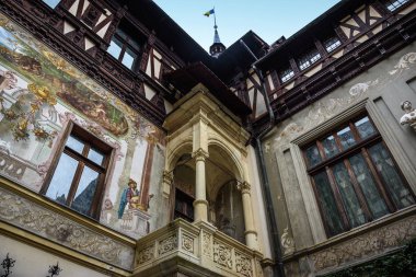 Sinaia, Romanya - 6 Kasım 2018. Romanya 'nın Sinaia kentindeki Karpat Dağları' nda bulunan Peles Kalesi avlusunun dış duvarları. Resimler ve ahşap süslemeler..