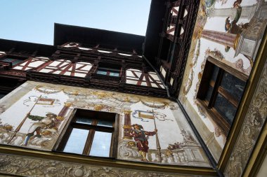 Sinaia, Romanya - 6 Kasım 2018. Romanya 'nın Sinaia kentindeki Karpat Dağları' nda bulunan Peles Kalesi avlusunun dış duvarları. Resimler ve ahşap süslemeler..
