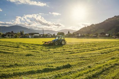 Hasat alanında yaz akşamı peyzaj ve traktör ,Tirol, Avusturya