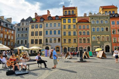 Varşova, Polonya - 29 Haziran 2018. Renkli ve geleneksel binalar, restoranlar, kafeler, turistler, Varşova portre ressamları ile Old Town Market Square (Rynek Starego Miasta).