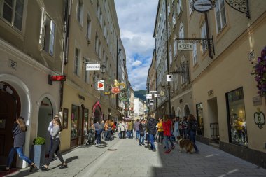 Salzburg, Avusturya - 25 Temmuz 2017. Getreidegasse 'de gezen turistler, Salzburgs City' deki ünlü alışveriş caddesi, Mozarts Doğum Yeri, dünyanın dört bir yanından gelen ziyaretçiler için karşı konulmaz bir yer.